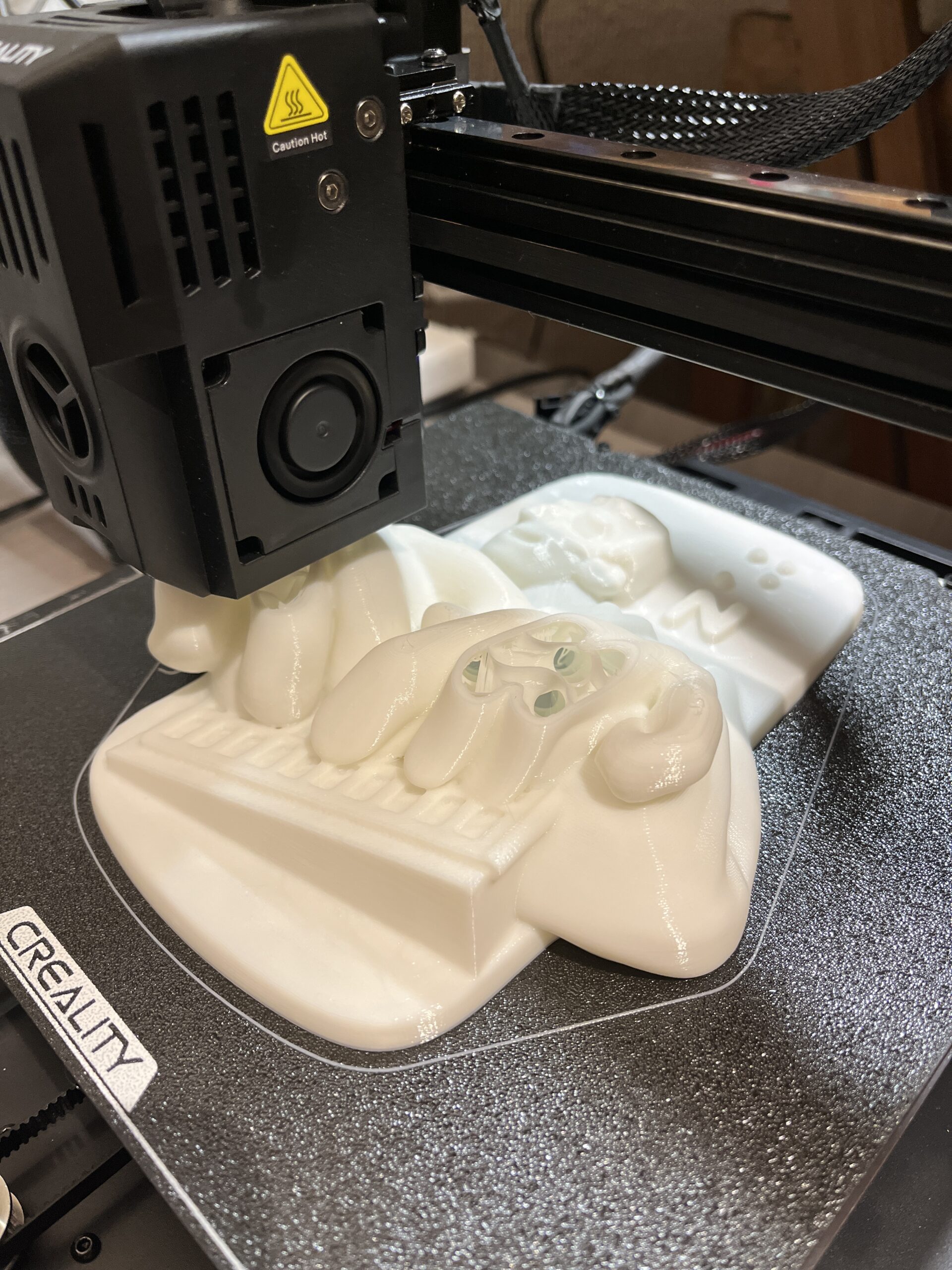 Fotografía de una impresora 3D, imprimiendo una réplica de una ilustración de Luis Braille en alto relieve.